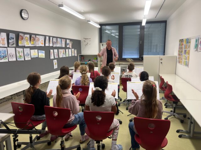 Zu Besuch bei unseren Bläserklassen der Grundschule Herschfeld 🎶🥁
Die Schüler der 3. Klasse (1. Bild) lernen momentan die Grundlagen ihrer Instrumente und des gemeinsamen Zusammenspiels. Auf dem Bild sehen wir, wie Peppi mit ihnen Rythmusübungen macht 🎷.
Die Schüler der 4. Klasse (2. und 3. Bild) schaffen es schon verschiedenste Lieder auf ihren Instrumenten zu spielen. Zusammen in einem kleinen Orchester hört sich das schon sehr gut an .